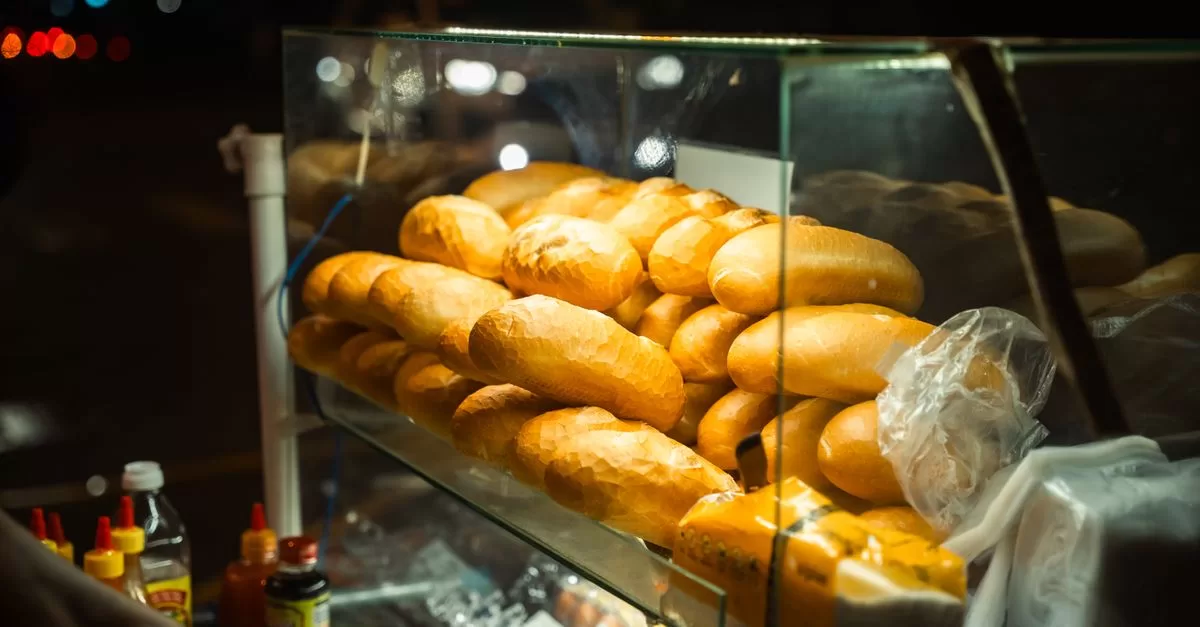 A street food cart with fresh baguettes at night