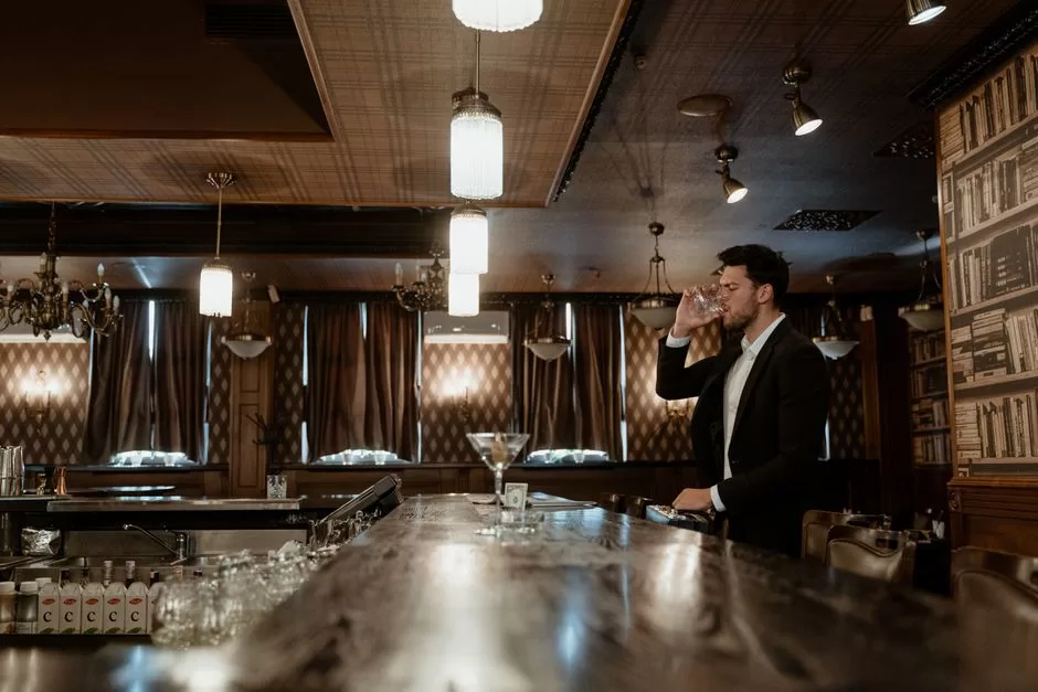 A cocktail on the counter of a dimly lit bar