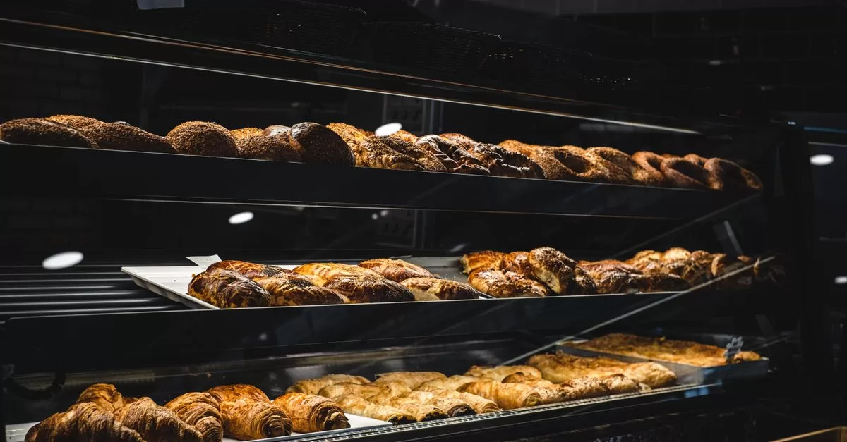 A variety of breads and pastries on a glass display counter