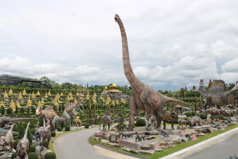 A dinosaur sculpture in a park