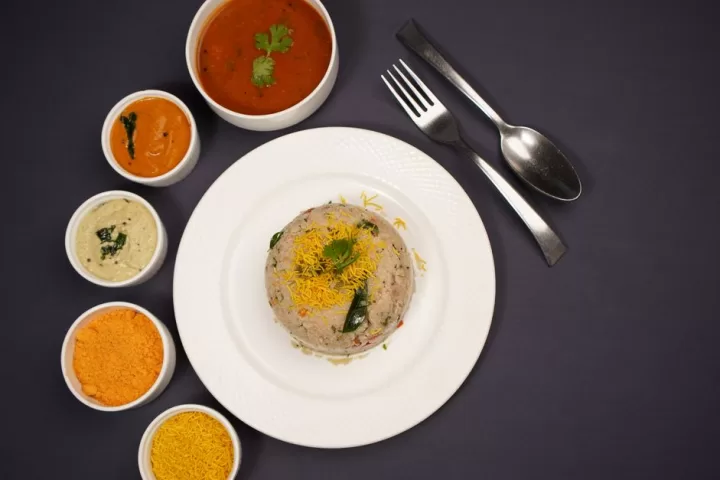 Indian round dish with spices and sauces on the side