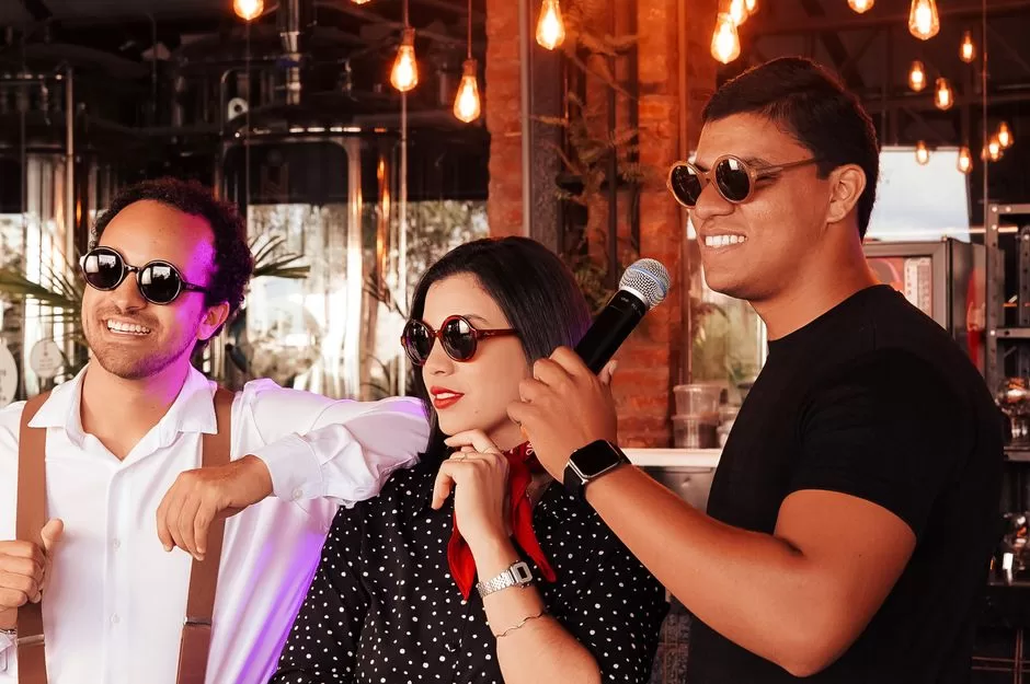 Three friends sharing a microphone at karaoke