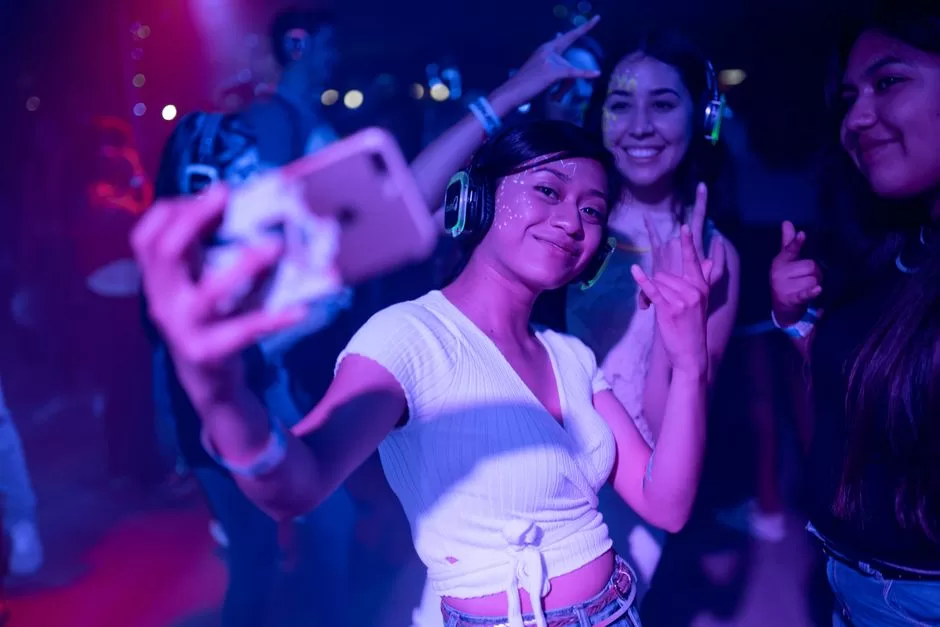 Young people dancing under neon light at a silent disco