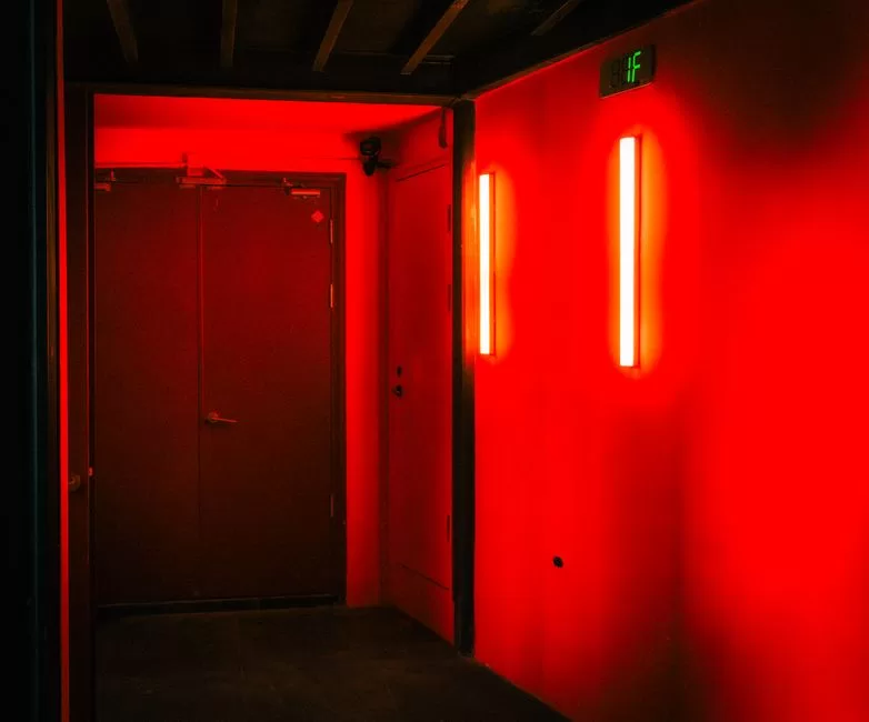 A dark corridor lit in red
