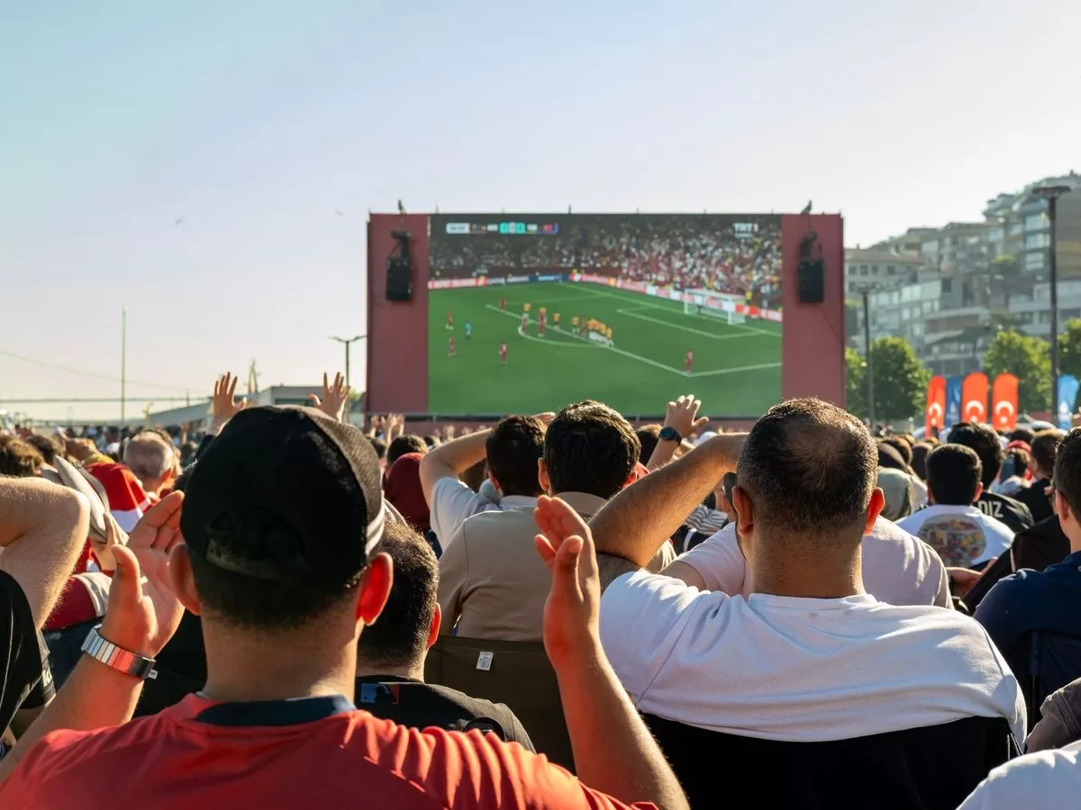 Fans watching football on a screen in a pub